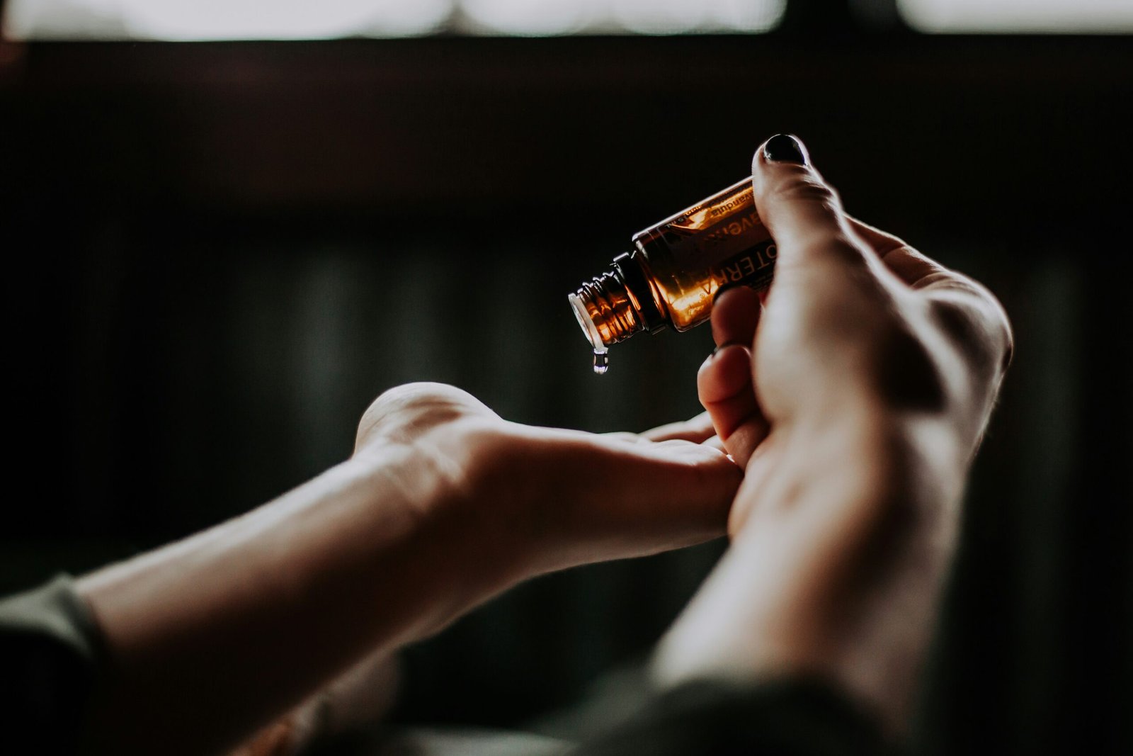 mujer poniéndose aceite esencial en sus manos